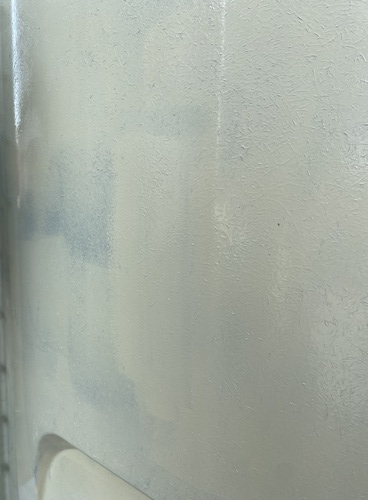 FRP水タンクの中塗り後に下地が部分的に透けて見える表面
