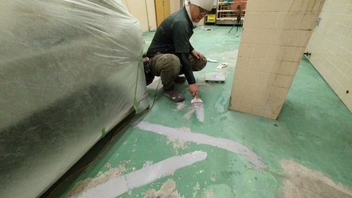 合志市の旅館厨房で床のひび割れと欠損部分を補修する様子