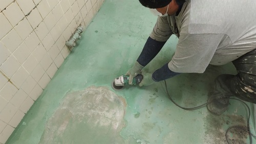 合志市の旅館厨房で既存床を機械研磨している施工中の様子