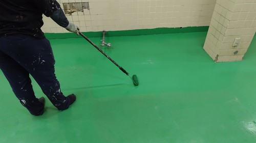 合志市の旅館厨房で滑り止め処理後の床を仕上げ塗装する様子