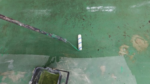 合志市の旅館厨房で研磨後の床にプライマーを塗装する様子